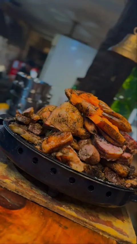 Brasero para cuatro con asado, pollo, bondiola rellena y boniato sobre las brasas